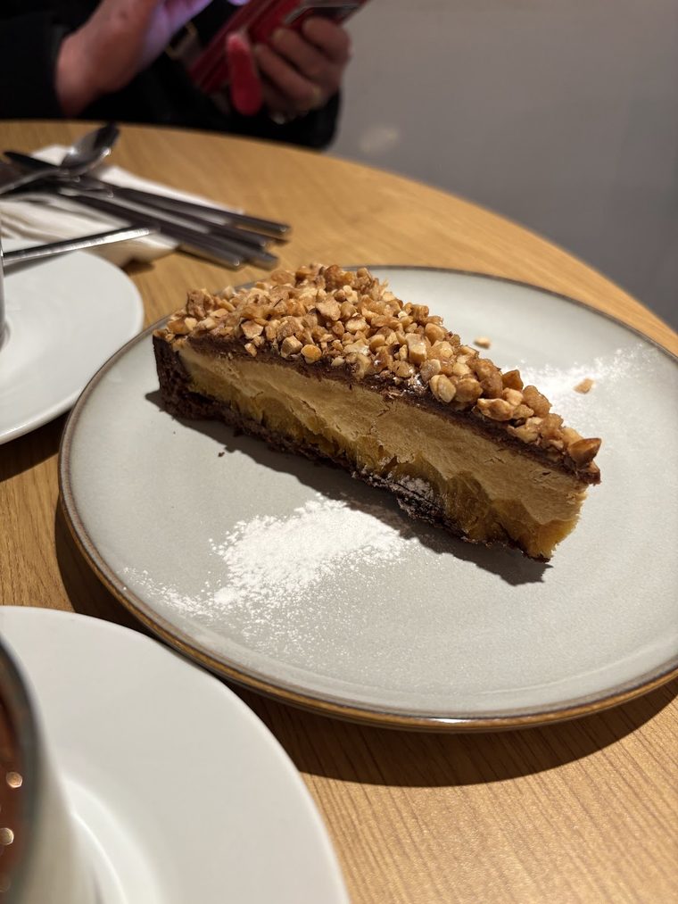 Caramel and chocolate hazelnut tart slice on a stoneware plate
